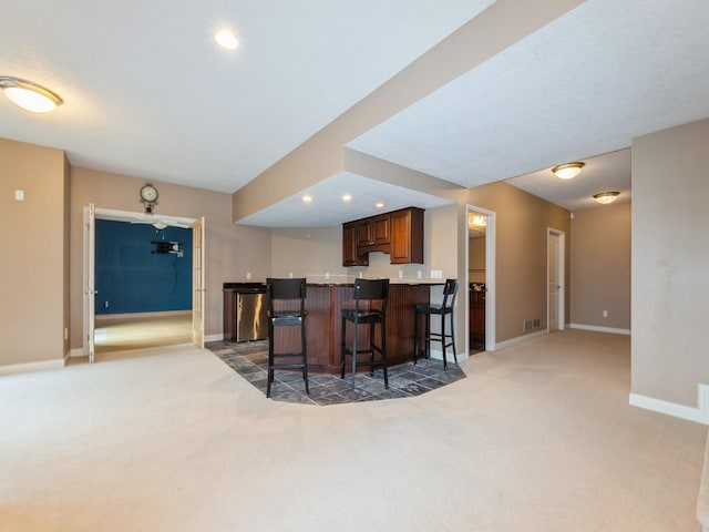 2705 147th St, Urbandale, IA 50323 - kitchen featuring light carpet, a breakfast bar, a peninsula, and recessed lighting