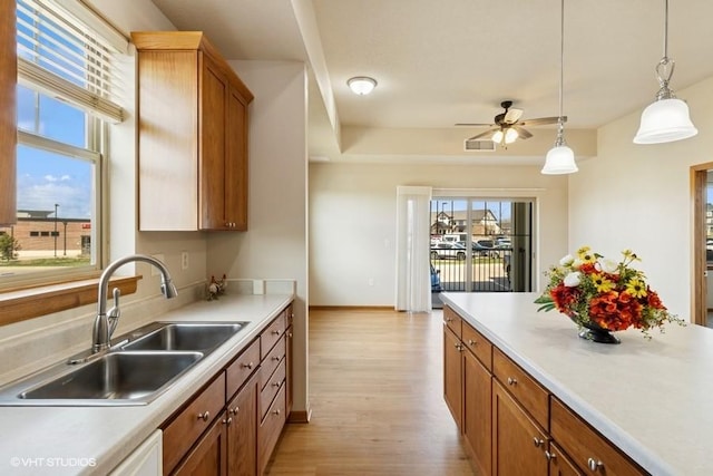 1370 SW Magazine Rd Unit 101, Ankeny, IA 50023 - kitchen featuring light wood finished floors, light countertops, visible vents, a sink, and pendant lighting