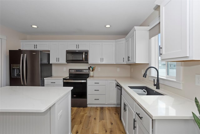 3121 NW 27th Cir, Ankeny, IA 50023 - kitchen with stainless steel appliances, a sink, light wood-style flooring, white cabinets, and recessed lighting