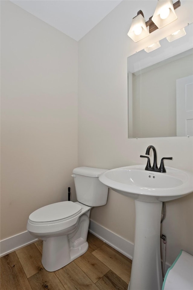 3121 NW 27th Cir, Ankeny, IA 50023 - bathroom featuring baseboards, toilet, and wood finished floors