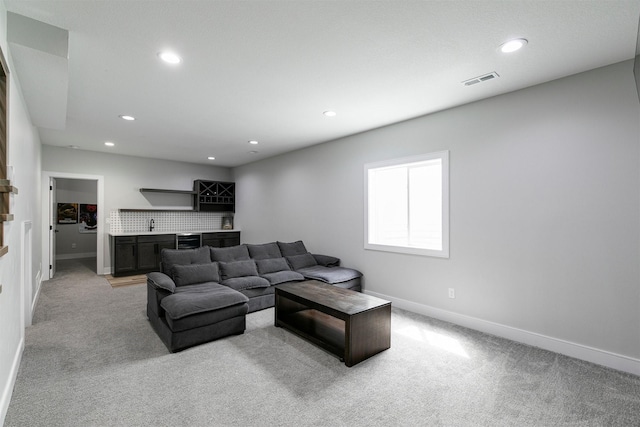 16318 Goldenrod Dr, Urbandale, IA 50323 - living area featuring indoor wet bar, light colored carpet, and baseboards