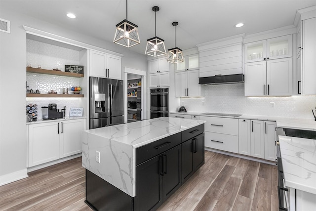 16318 Goldenrod Dr, Urbandale, IA 50323 - kitchen with fridge with ice dispenser, double wall oven, a kitchen island, under cabinet range hood, and dark cabinetry