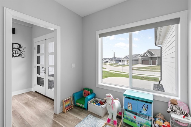16318 Goldenrod Dr, Urbandale, IA 50323 - game room featuring french doors, baseboards, and wood finished floors