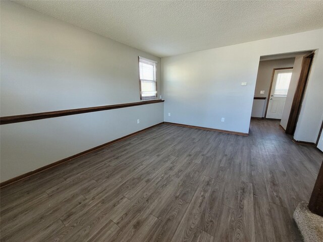 1761 E Lacona Ave, Des Moines, IA 50320 - unfurnished room featuring dark wood-style flooring, baseboards, and a textured ceiling