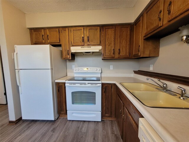1761 E Lacona Ave, Des Moines, IA 50320 - kitchen featuring white appliances, light countertops, under cabinet range hood, a sink, and wood finished floors
