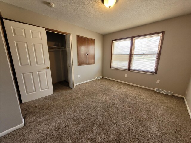 1761 E Lacona Ave, Des Moines, IA 50320 - unfurnished bedroom featuring a closet, carpet, visible vents, and a textured ceiling