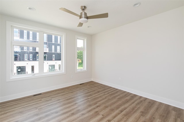 unfurnished room featuring visible vents, baseboards, and wood finished floors