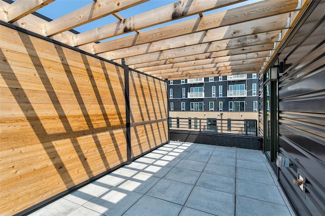 view of patio featuring a pergola and a balcony