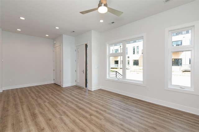 empty room featuring light wood finished floors, visible vents, and recessed lighting