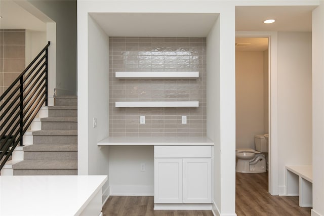 stairs featuring wood finished floors and recessed lighting