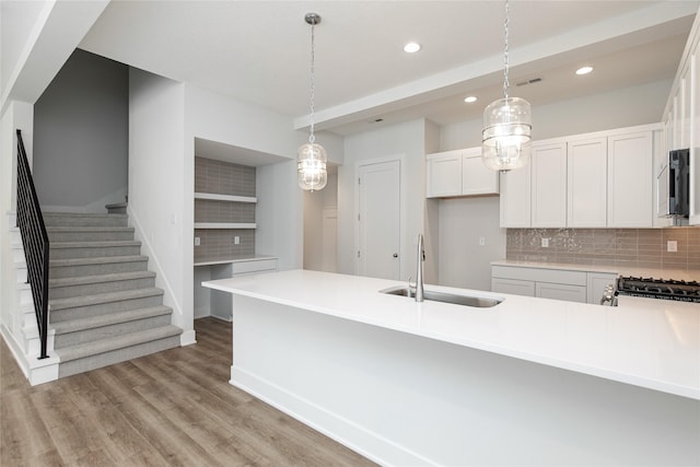kitchen featuring recessed lighting, backsplash, appliances with stainless steel finishes, a sink, and hanging light fixtures