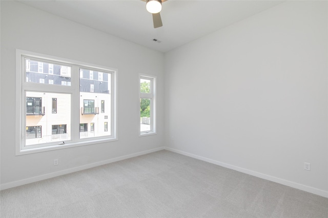 unfurnished room featuring light carpet, ceiling fan, and baseboards