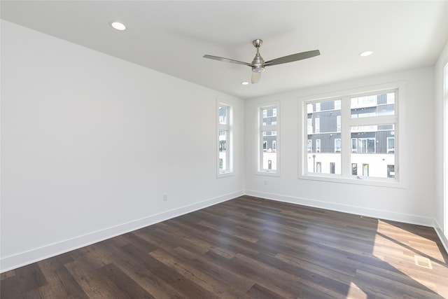 empty room featuring dark wood finished floors, a ceiling fan, and plenty of natural light