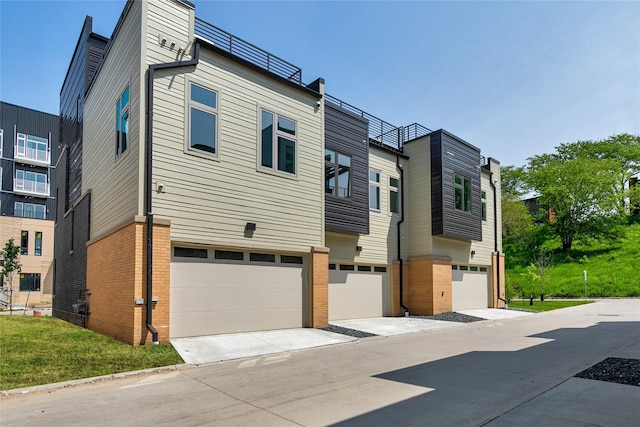exterior space with a garage, concrete driveway, and brick siding