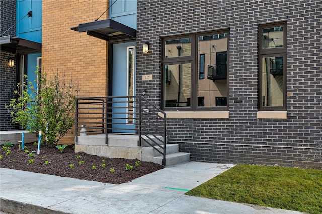 doorway to property featuring brick siding