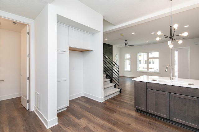 kitchen featuring a sink, dark wood-style floors, and baseboards