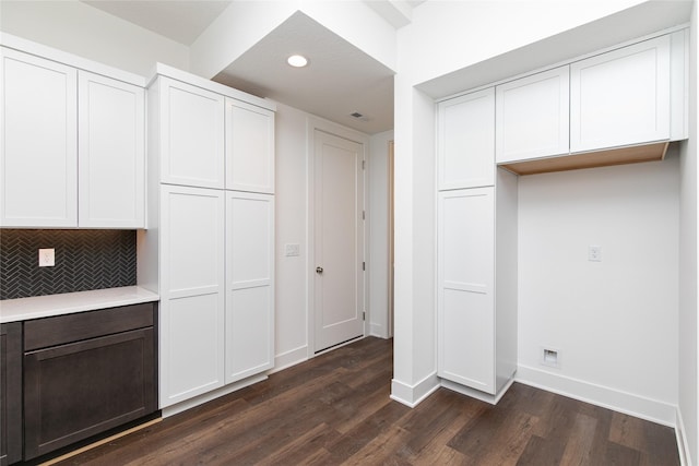 kitchen featuring dark wood-style flooring, light countertops, white cabinetry, and baseboards