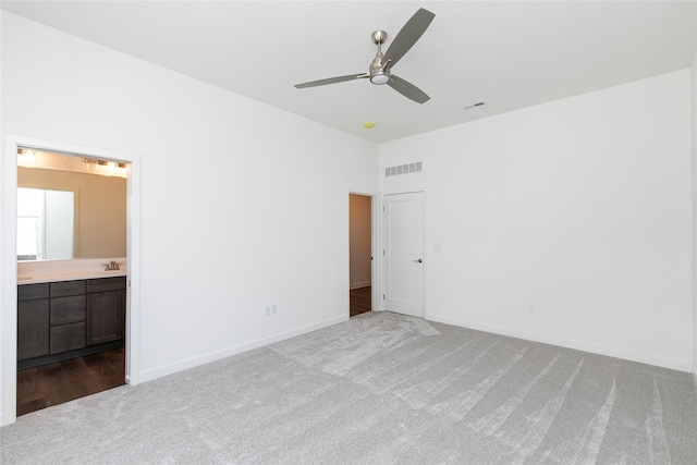 unfurnished bedroom with carpet flooring, visible vents, baseboards, and connected bathroom