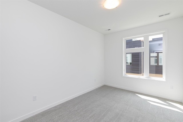 unfurnished room featuring baseboards, carpet, and visible vents