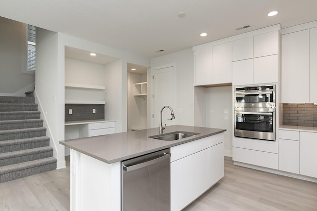 213 Maple St, Des Moines, IA 50309 - kitchen featuring white cabinets, tasteful backsplash, a sink, and appliances with stainless steel finishes