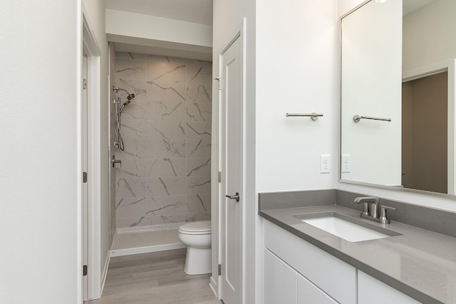 213 Maple St, Des Moines, IA 50309 - full bathroom with a shower stall, vanity, toilet, and wood finished floors