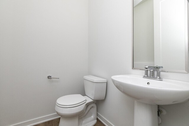 209 Maple St, Des Moines, IA 50309 - bathroom with toilet, baseboards, and wood finished floors