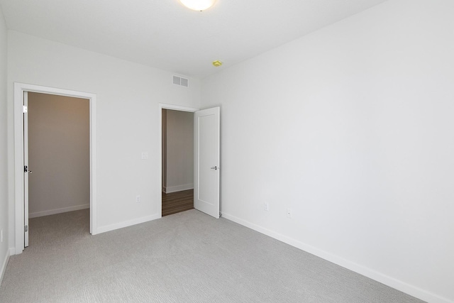 209 Maple St, Des Moines, IA 50309 - unfurnished bedroom with a closet, light colored carpet, visible vents, a walk in closet, and baseboards