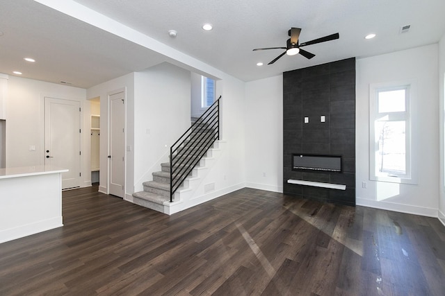 205 Maple St, Des Moines, IA 50309 - unfurnished living room featuring dark wood-style flooring, a fireplace, a ceiling fan, and visible vents