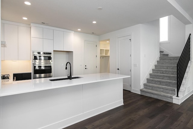 205 Maple St, Des Moines, IA 50309 - kitchen featuring recessed lighting, white cabinets, dark wood-type flooring, double oven, and a sink