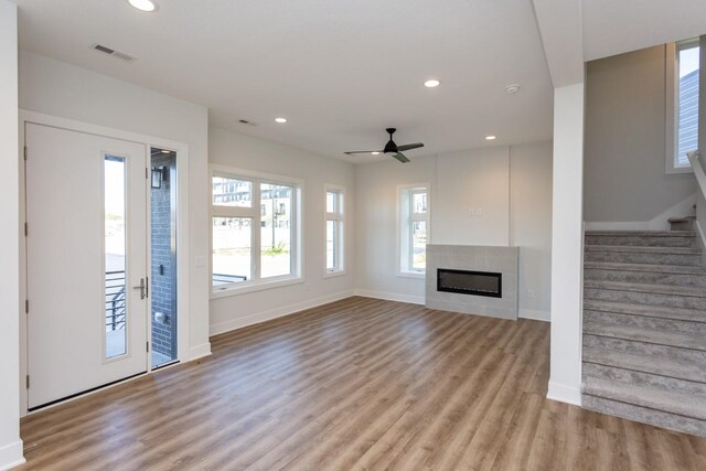 859 E 2nd St, Des Moines, IA 50309 - unfurnished living room with visible vents, baseboards, recessed lighting, light wood finished floors, and stairway