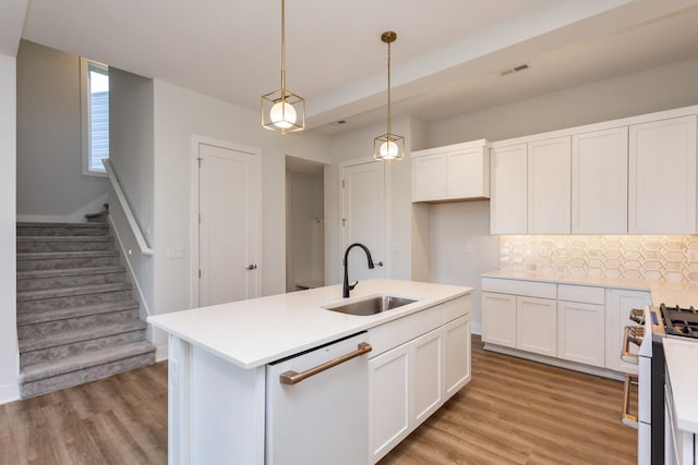 859 E 2nd St, Des Moines, IA 50309 - kitchen featuring tasteful backsplash, gas range oven, white cabinetry, white dishwasher, and a sink