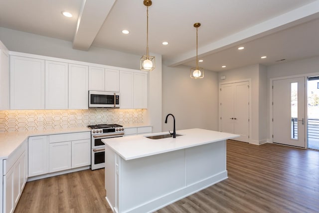 859 E 2nd St, Des Moines, IA 50309 - kitchen with white microwave, backsplash, wood finished floors, a sink, and range with two ovens