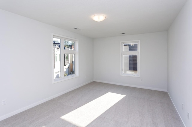 859 E 2nd St, Des Moines, IA 50309 - unfurnished room with visible vents, baseboards, and light carpet