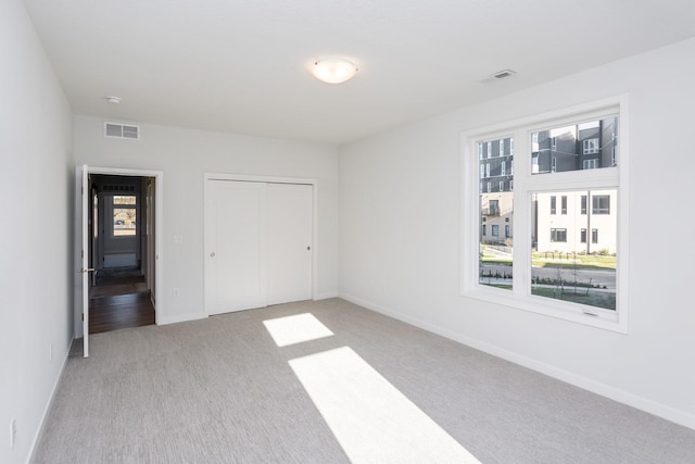 859 E 2nd St, Des Moines, IA 50309 - unfurnished bedroom featuring visible vents, baseboards, and light carpet