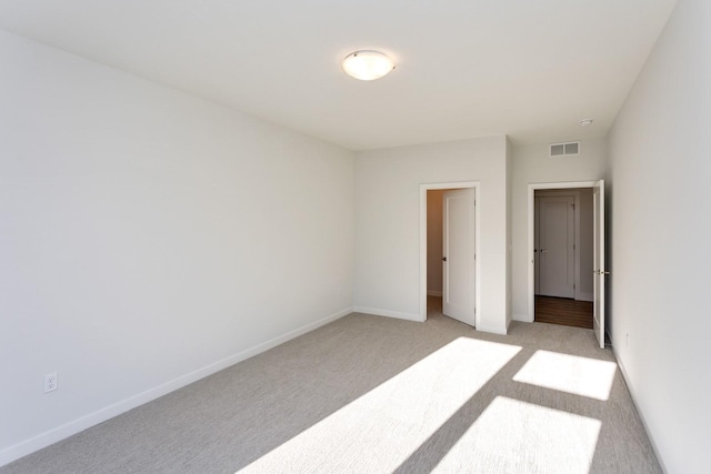 859 E 2nd St, Des Moines, IA 50309 - unfurnished bedroom with visible vents, baseboards, and light carpet