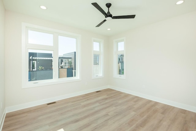 spare room featuring recessed lighting, light wood-type flooring, and baseboards
