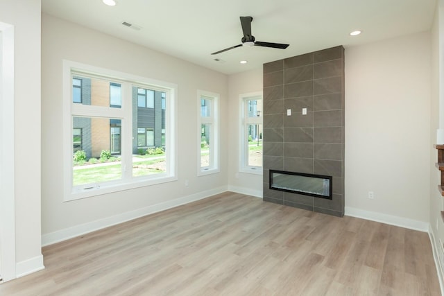 unfurnished living room featuring light wood-style floors, ceiling fan, visible vents, recessed lighting, and a tile fireplace