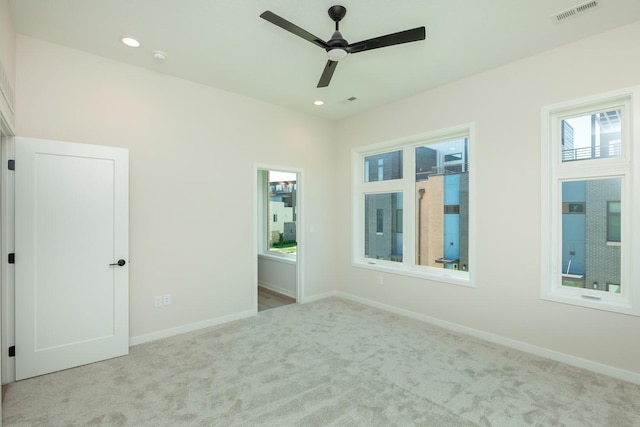 carpeted empty room featuring recessed lighting, visible vents, baseboards, and ceiling fan