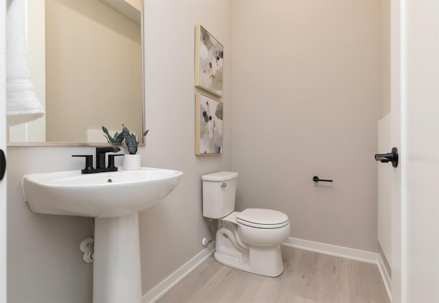 820 E 2nd St, Des Moines, IA 50309 - half bath with toilet, baseboards, and wood finished floors