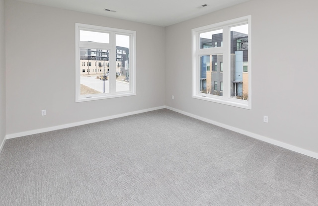 820 E 2nd St, Des Moines, IA 50309 - spare room featuring visible vents, baseboards, and carpet flooring
