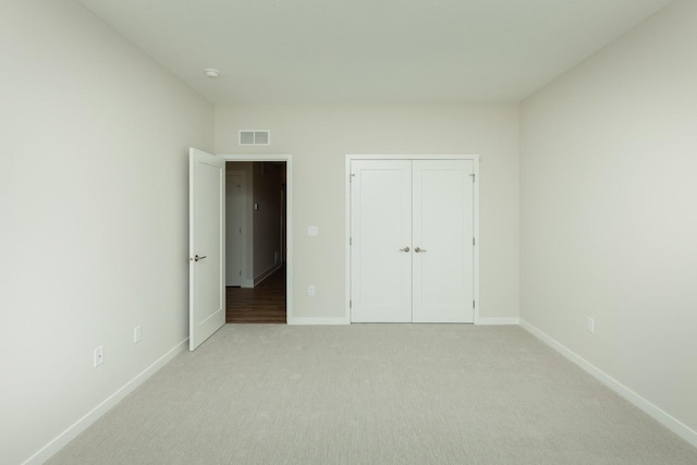 822 E 2nd St, Des Moines, IA 50309 - unfurnished bedroom with a closet, light colored carpet, baseboards, and visible vents