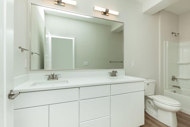 822 E 2nd St, Des Moines, IA 50309 - full bath featuring toilet, wood finished floors, double vanity, and a sink