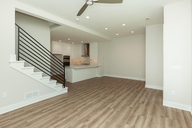 822 E 2nd St, Des Moines, IA 50309 - unfurnished living room with light wood-type flooring, a ceiling fan, visible vents, stairway, and recessed lighting