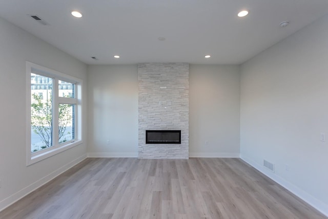 unfurnished living room with light wood-style floors, a fireplace, visible vents, and recessed lighting