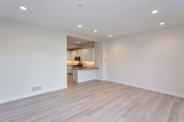 unfurnished living room featuring visible vents, baseboards, light wood finished floors, and recessed lighting