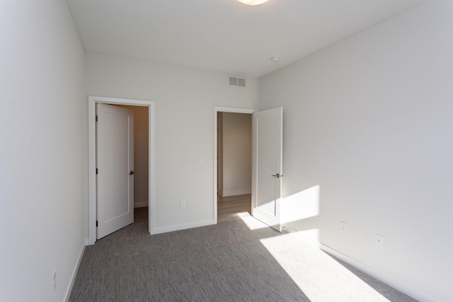 unfurnished bedroom with visible vents, baseboards, and carpet