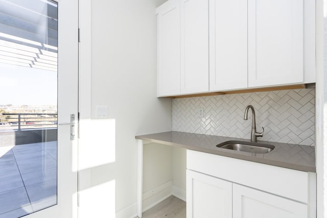 interior space with a sink, baseboards, and light wood-style floors