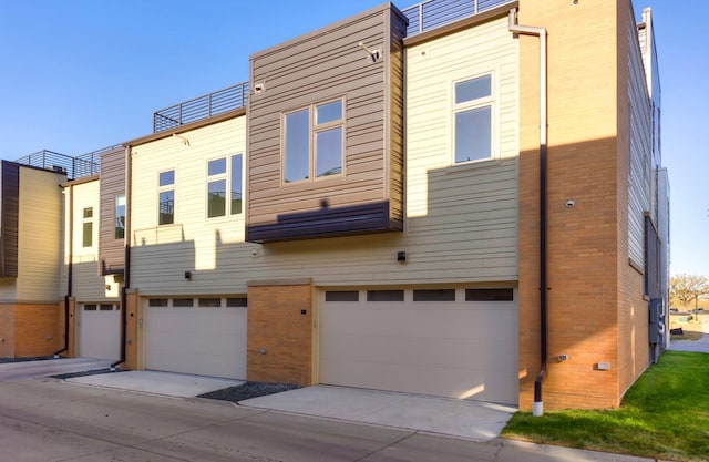 back of house featuring brick siding and a garage