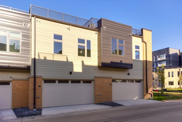 view of front facade featuring brick siding, driveway, and an attached garage
