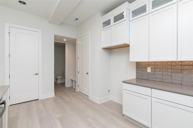 225 Maple St, Des Moines, IA 50309 - kitchen with light wood finished floors, glass insert cabinets, white cabinetry, and baseboards